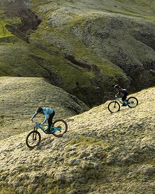 Naine sõidab jalgrattal Thule Vital vedelikukotiga läbi karmi Islandi maapiirkonna.