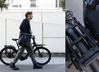 Person walking a bike with a bag mounted using the InLock pannier system by Thule.