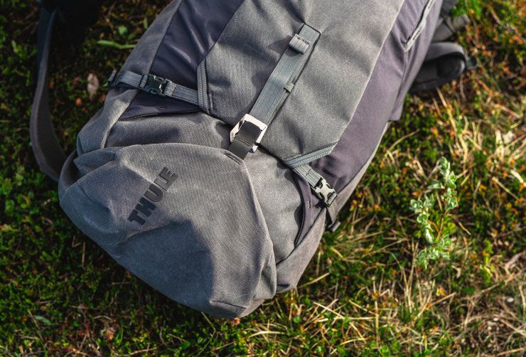 Close-up of a gray Thule AllTrail hiking backpack on the grass.