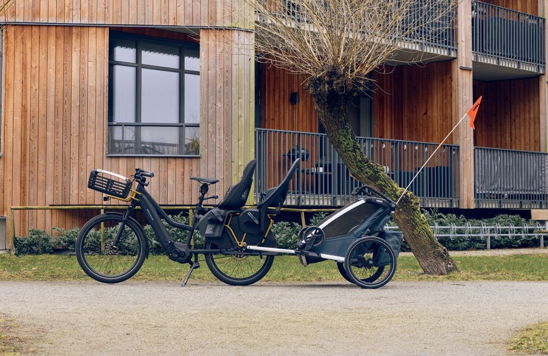 Bicicleta longtail com cesto Thule, cadeirinhas infantis e trailer para bicicletas.