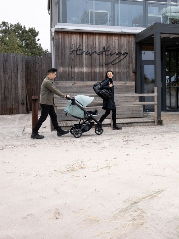 一男一女推著 Thule Spring 2 嬰兒車走路