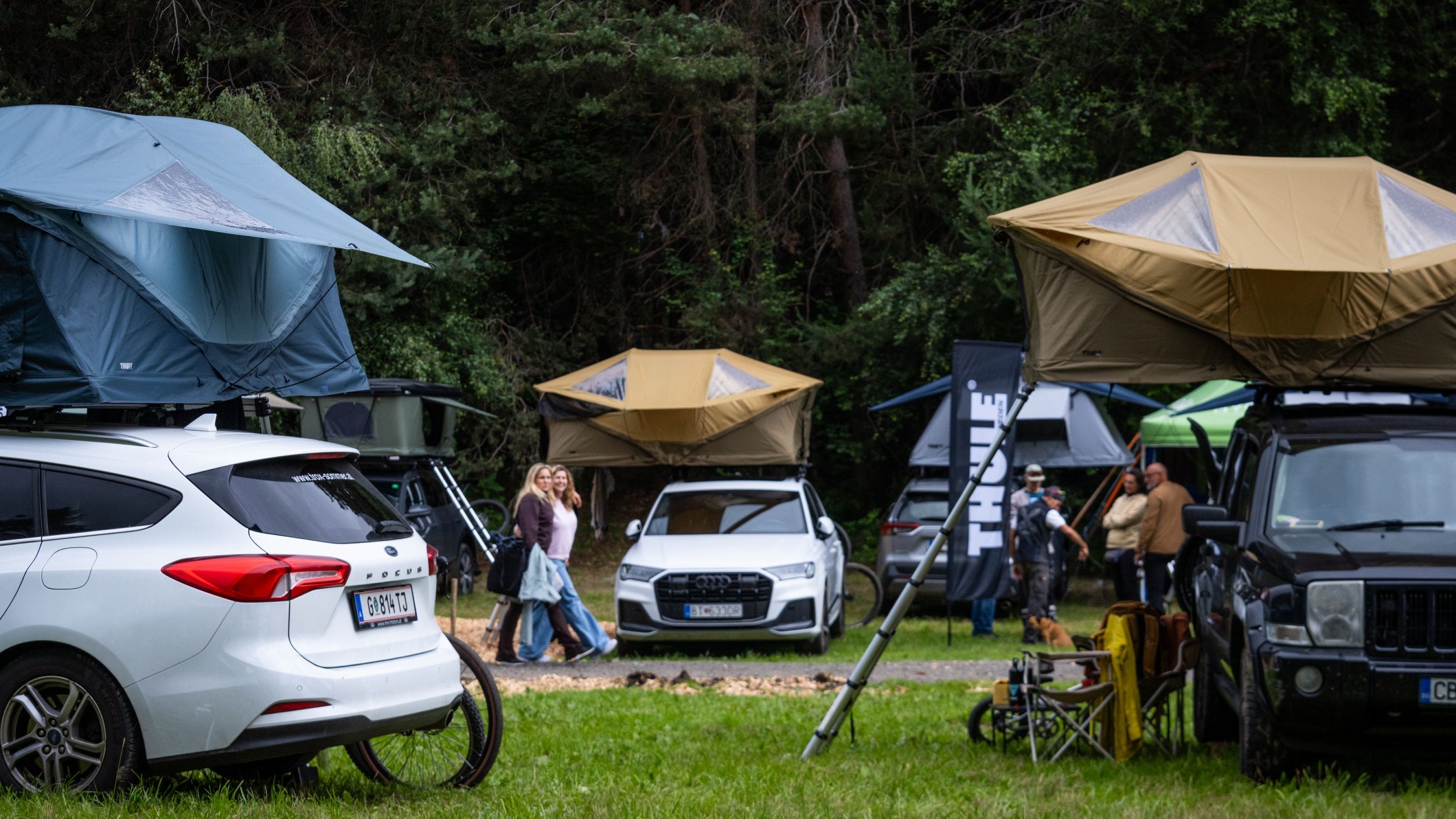 Autos, die mit Thule Dachzelten ausgestattet sind, sind beim Adventure Life by Thule in Innsbruck geparkt.