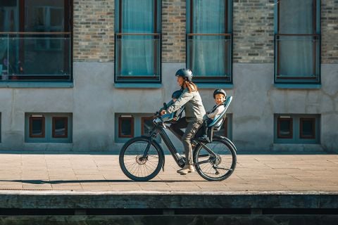 Pessoa a andar de bicicleta com crianças tanto num mini Thule Yepp 2 como num Thule Yepp 2.