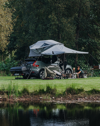 Roof top tent camping setup in nature by a lake