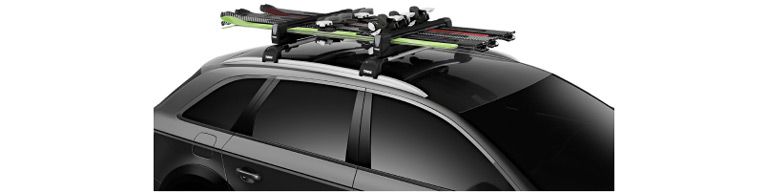 A close-up of a car with the Thule SnowPack Extender ski rack with a white background.