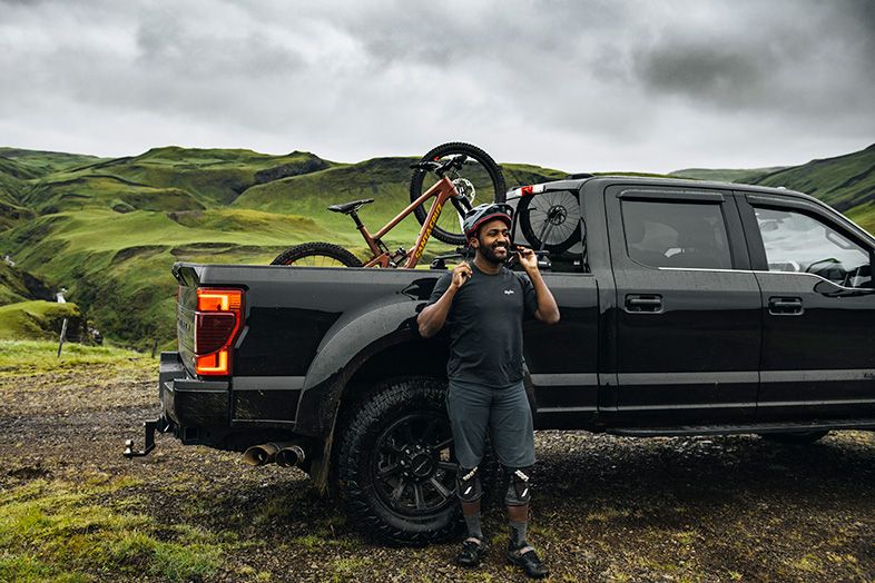 Eliot Jackson stands next to a truck with a bike mounted on the Thule Bedrider in the truck bed