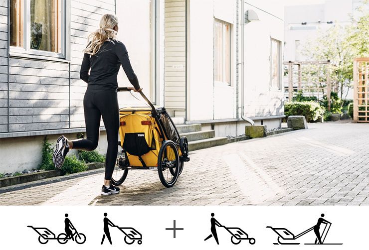 A woman goes for a jog with a yellow Thule Chariot Sport bike trailer