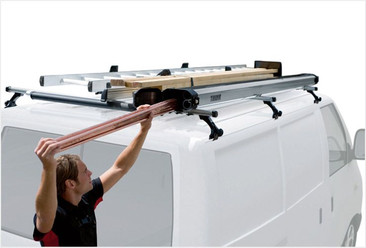 A close up of a Thule professional roof rack and a person loading their gear onto the rack