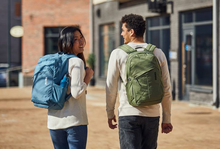 Two students with Thule back-to-campus backpacks go about their daily life on campus.