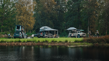 Tentes Thule sur le toit installées dans un emplacement de camping au bord de l’eau