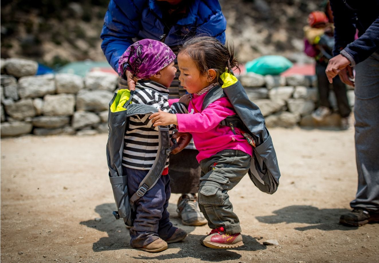 Twee kleine kinderen met rugzakken zijn aan het spelen.