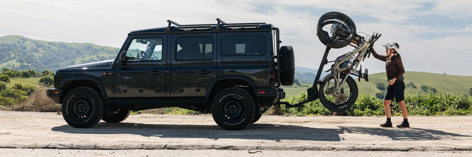 Personne chargeant un vélo sur un porte-vélos Thule Revert à l’arrière d’un VUS.