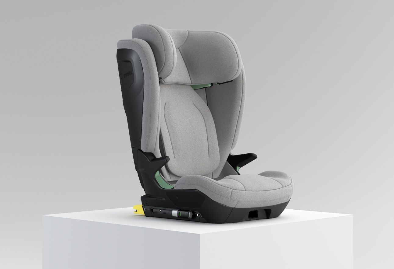 Vaaleanharmaa korotettu Thule Palm -turvaistuin valkoisella jalustalla valkoista taustaa vasten.