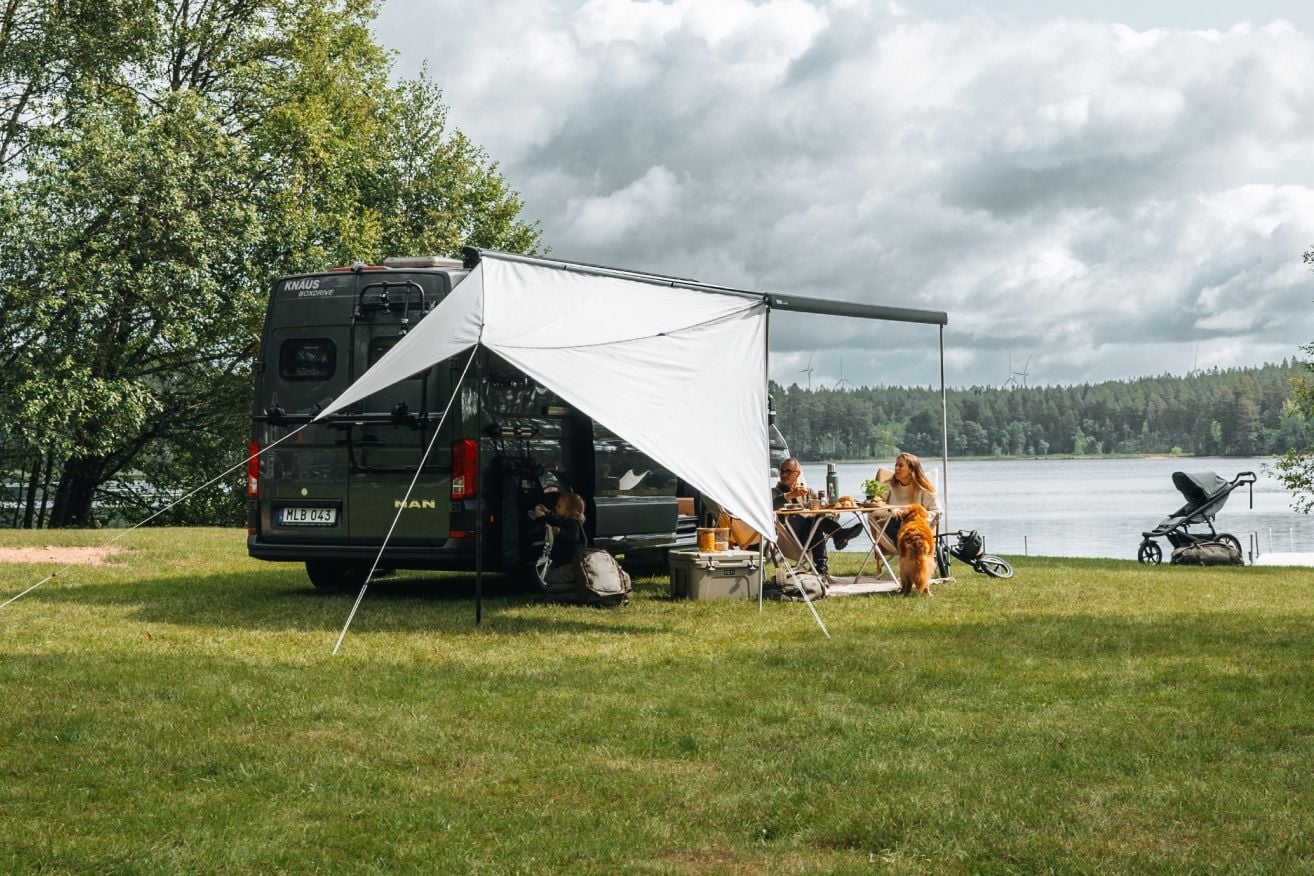 Van camping-car avec panneaux de tolis Thule Subsola créant un espace extérieur abrité.