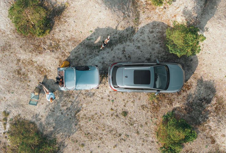 A bird’s eye view of the Thule Outset tent attached to a car parked in the countryside.