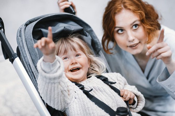 A close-up of a mother and her child pointing while the toddler sits in a Thule Shine stroller.