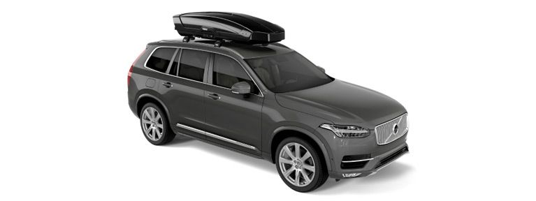 The Thule Motion XT rooftop cargo carrier on a car in a white background.