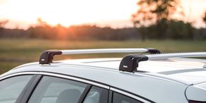 A close-up of a roof rack on a vehicle and a sunset in the background.