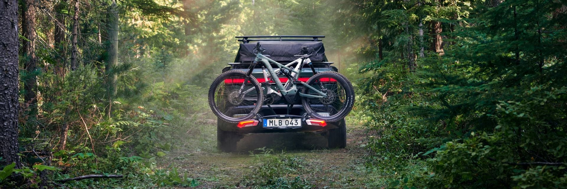 森の中を走る車に、トゥーレ・エポスの自転車ラックに自転車を取り付ける。