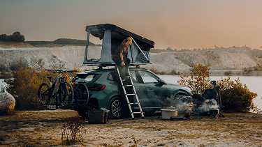 Thule šator na krovu postavljen uz vodu u zalazak sunca