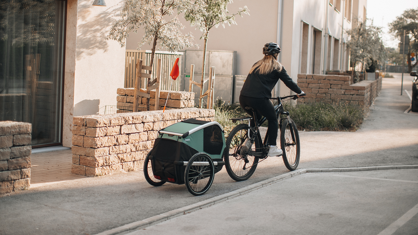 Cyclist towing a Thule bike trailer in the city