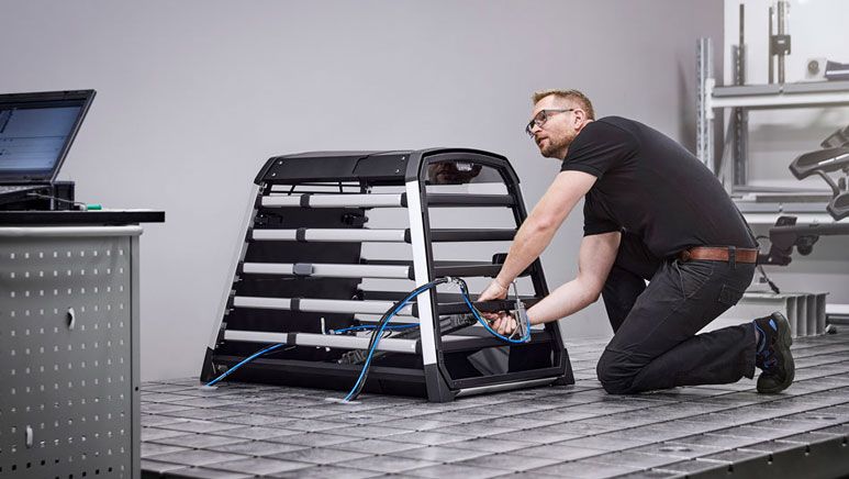 A man is mounting test equipment to a Thule Allax dog crate.