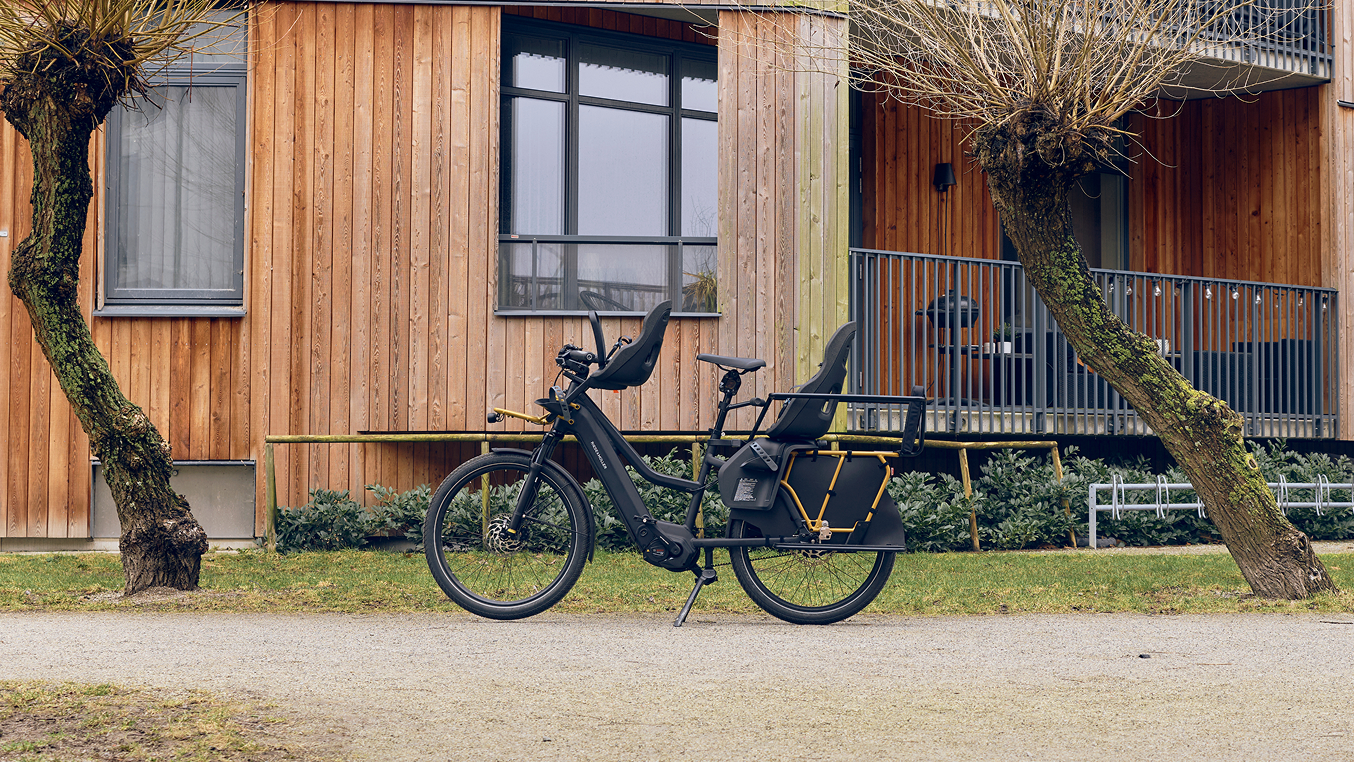 Bicicleta de cola larga con alforja Thule y silla para niños.
