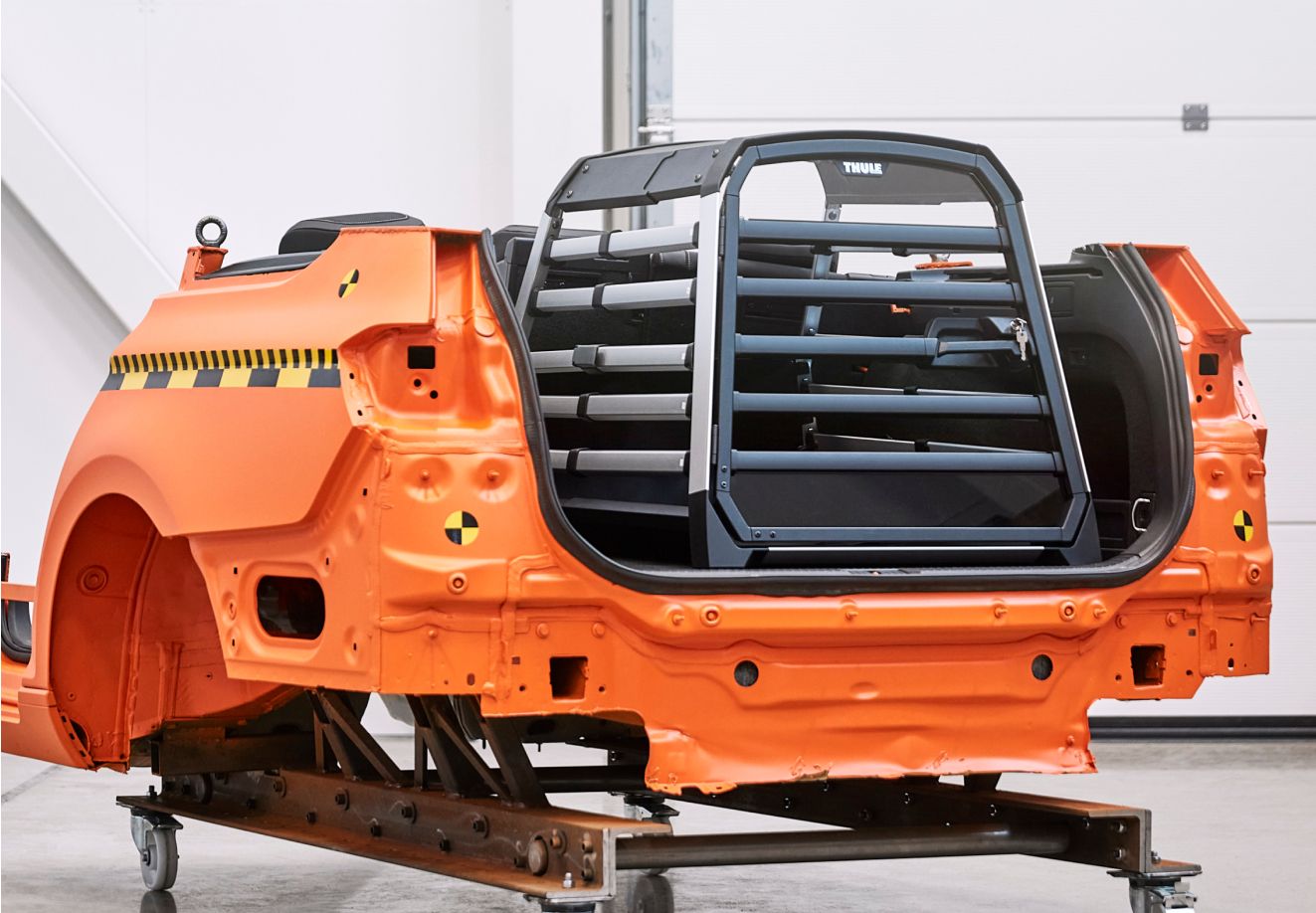 Transportador para cães Thule Allax no Thule Test Center colocado numa bagageira de simulação laranja.