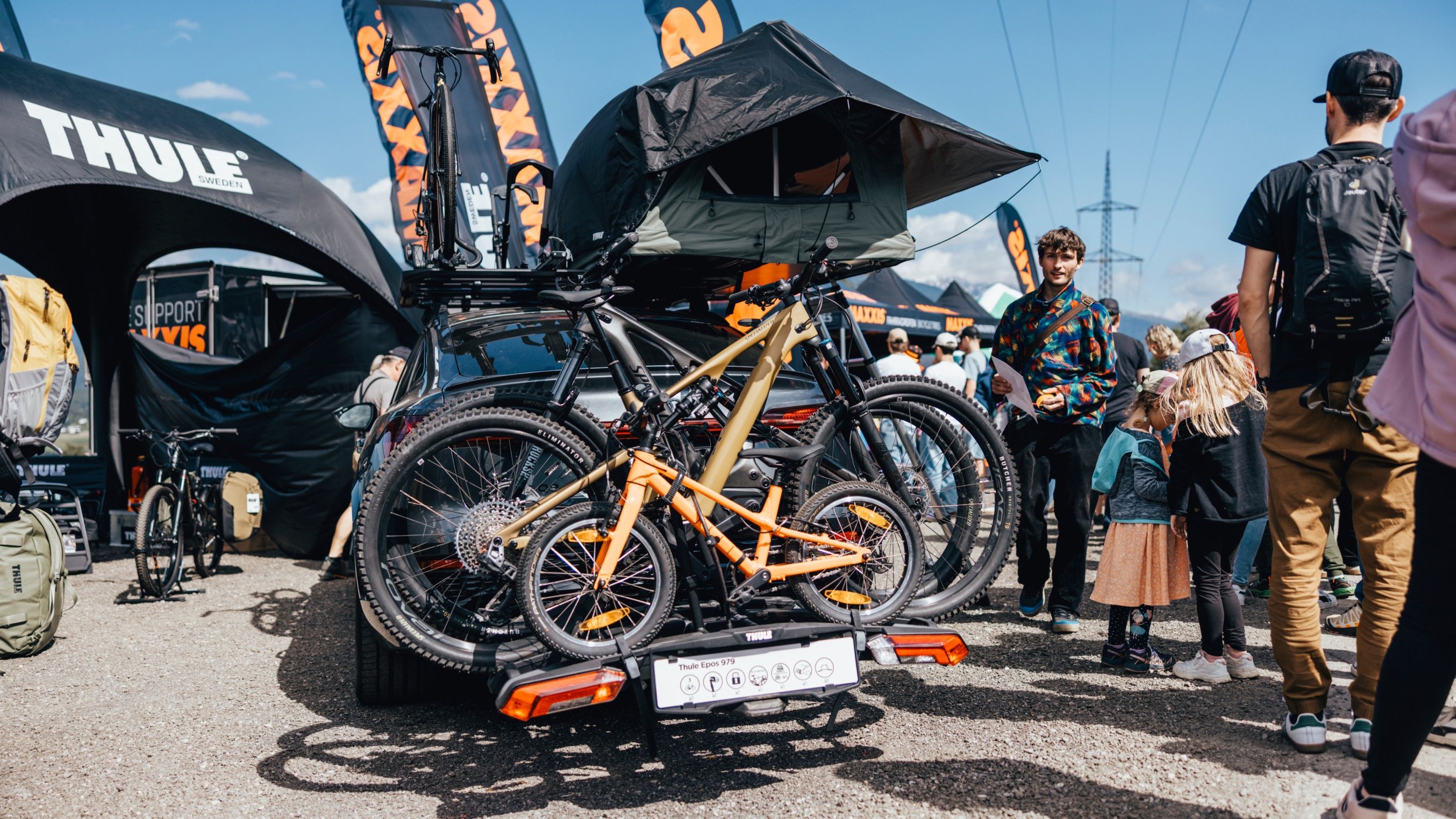 Automóvil equipado con un portabicicletas Thule Epos, una tienda de techo Thule Tepui, una plataforma de techo Thule Caprock y un portabicicletas Thule Freeride en el Festival Crankworx de Insbruuck.