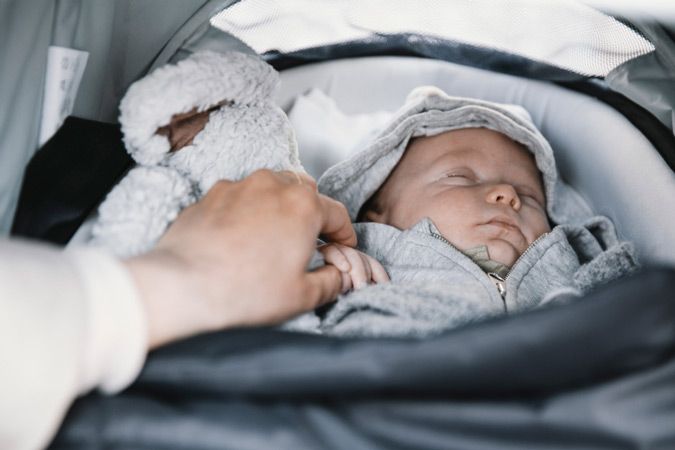 A close up of a newborn sleeping in the Thule Shine infant stroller.