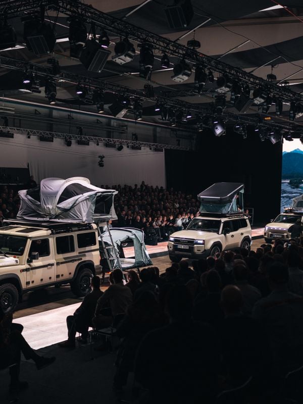 Een auto-catwalk met verschillende groene auto's, volgeladen met Thule-uitrusting