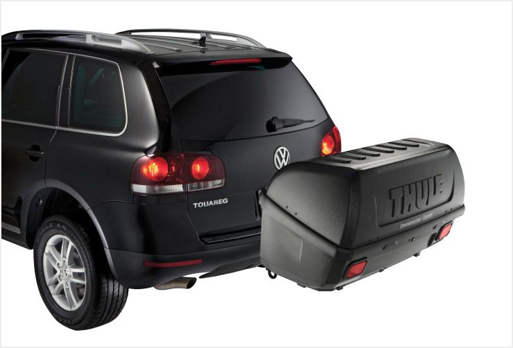 A zoomed in picture of a Thule Onto hitch cargo carrier mounted on a car.