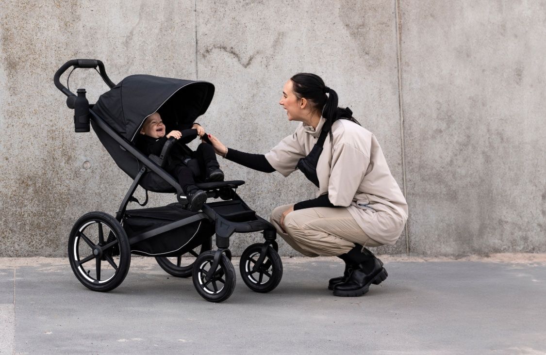 A woman laughs with her baby inside one of our best strollers for city strolling.