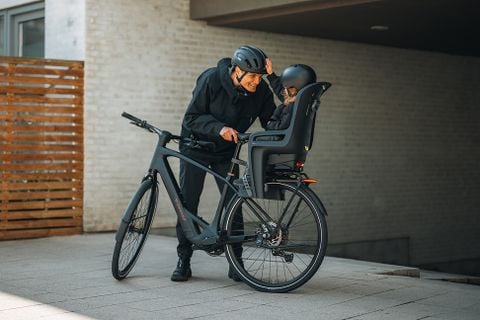 Person, die ein Lastrad mit zwei Thule Yepp Nexxt 2 Maxi-Kindersitzen fährt.