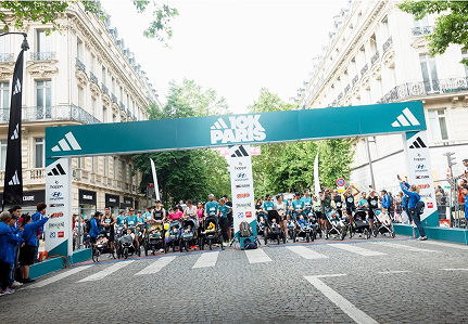 Una folla di persone si trova dietro dei passeggini sulla linea di partenza di una gara di 10 km a Parigi. 