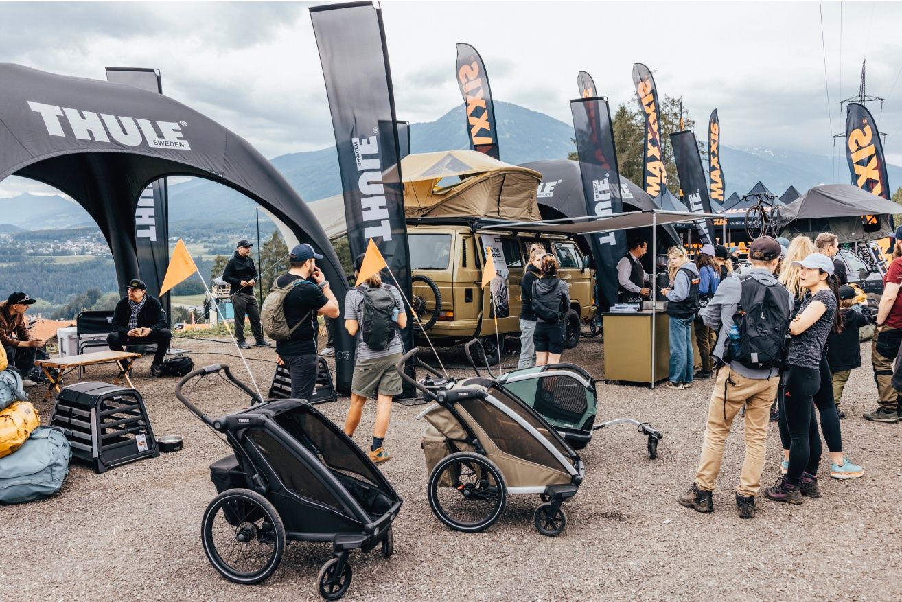 Visitantes reunidos alrededor del puesto de café de la casa rodante Thule en el festival Crankworx de Innsbruck.