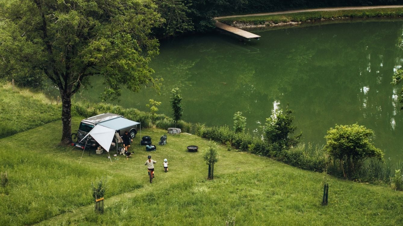Thule Subsola awning panels set up as a flexible shelter at a lakeside campsite.