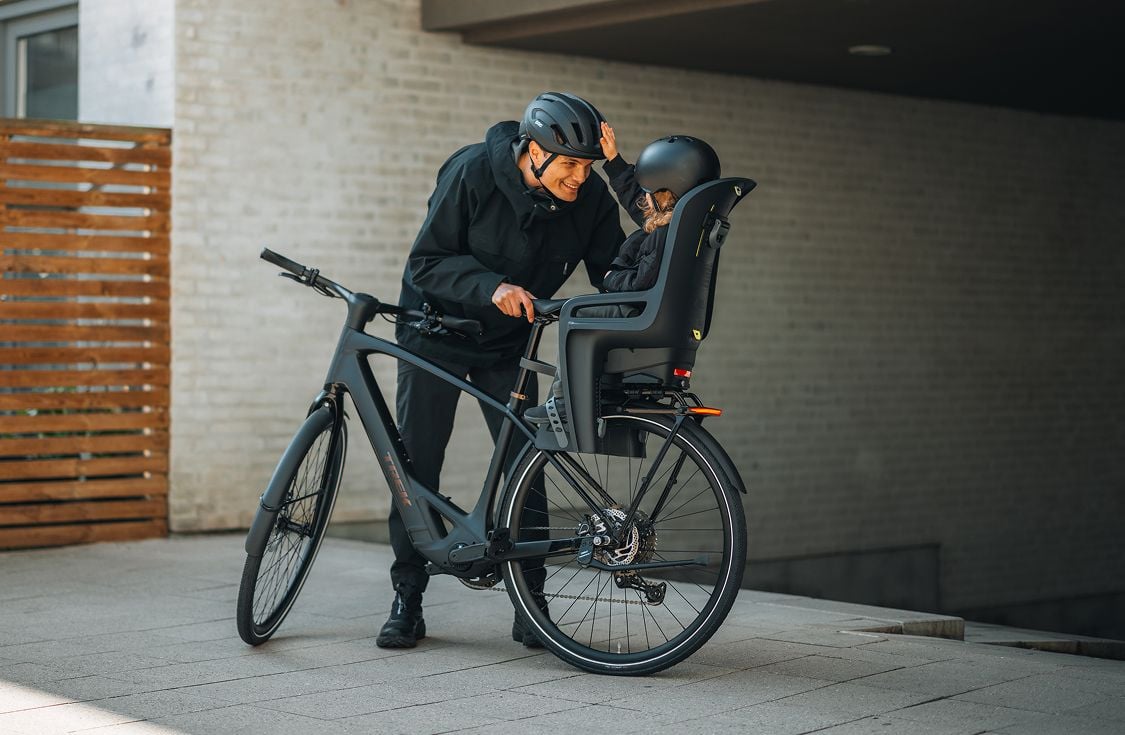 Person riding a cargo bike with two Thule Yepp Nexxt 2 maxi child bike seats.