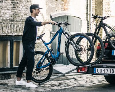一個騎自行車的人使用自行車架配件將自行車放上自行車架。