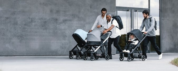 Three fathers push their babies in Thule Shine strollers and infant strollers.