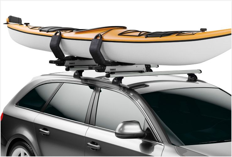 A zoomed in picture of a Thule Hullavator Pro kayak rack mounted on the roof of a car.