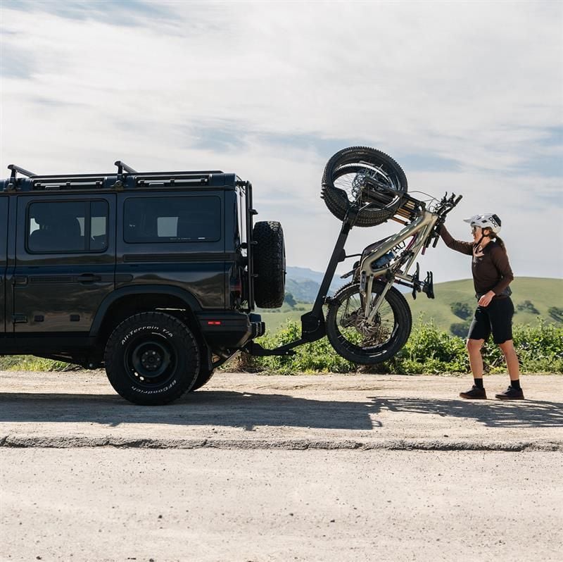 Personne chargeant un vélo sur un porte-vélos Thule Revert à l’arrière d’un VUS.