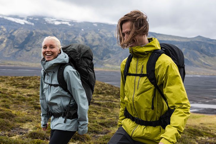 Two people hiking with backpacks in nature.