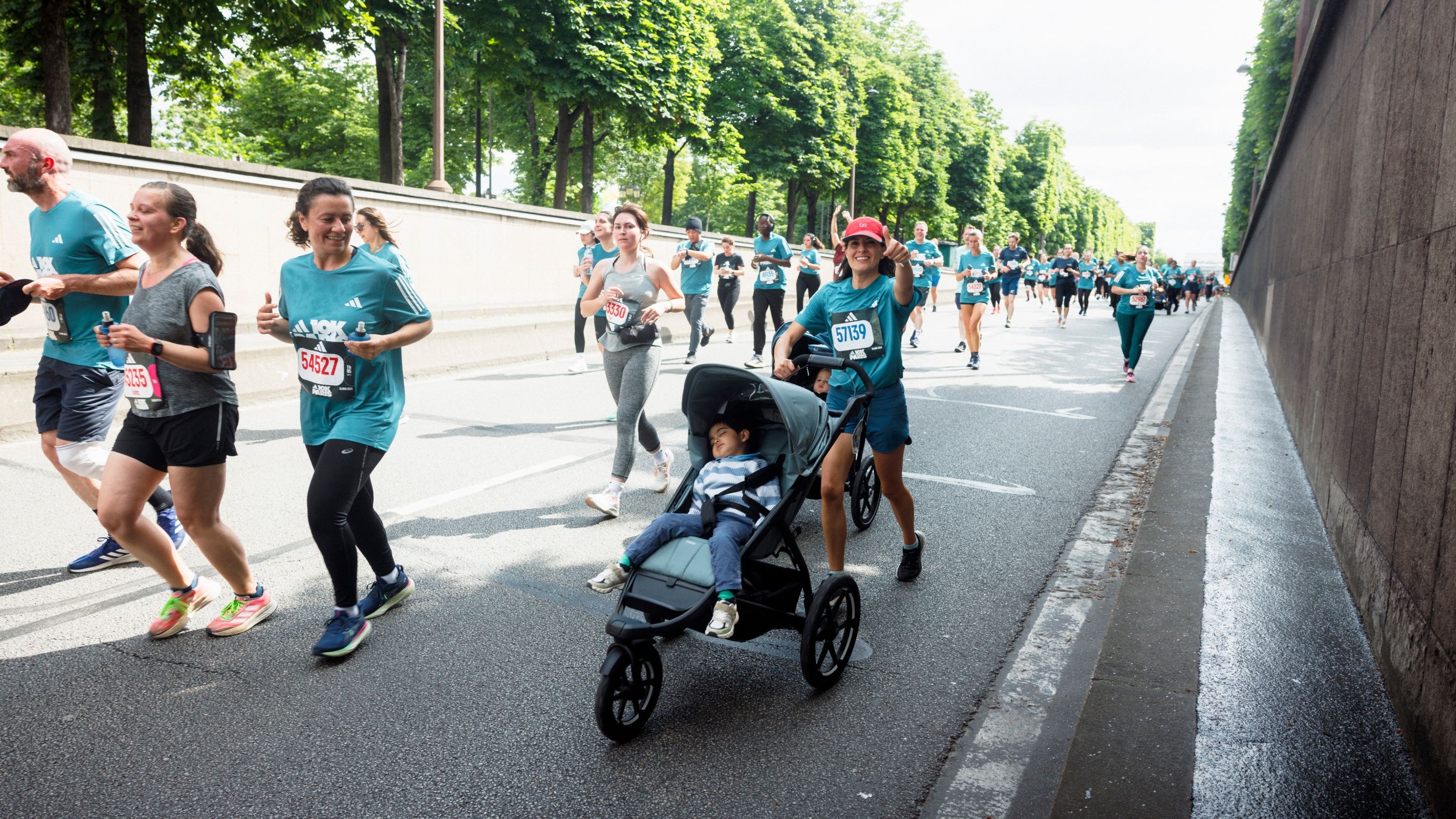 Participantes a correrem com carrinhos de bebé no Adidas 10K em Paris com carrinhos de bebé Thule Urban Glide.