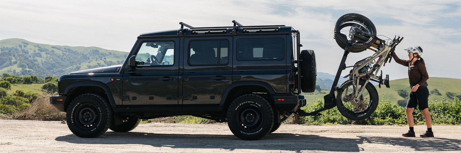 Personne chargeant un vélo sur un porte-vélos Thule Revert à l’arrière d’un VUS.