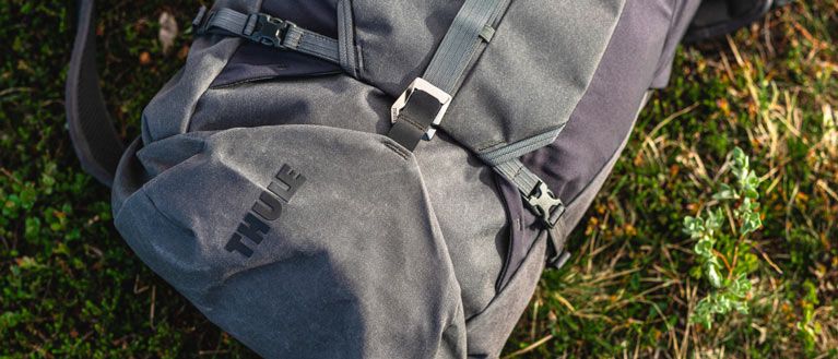 Close-up of a gray Thule AllTrail hiking backpack on the grass.