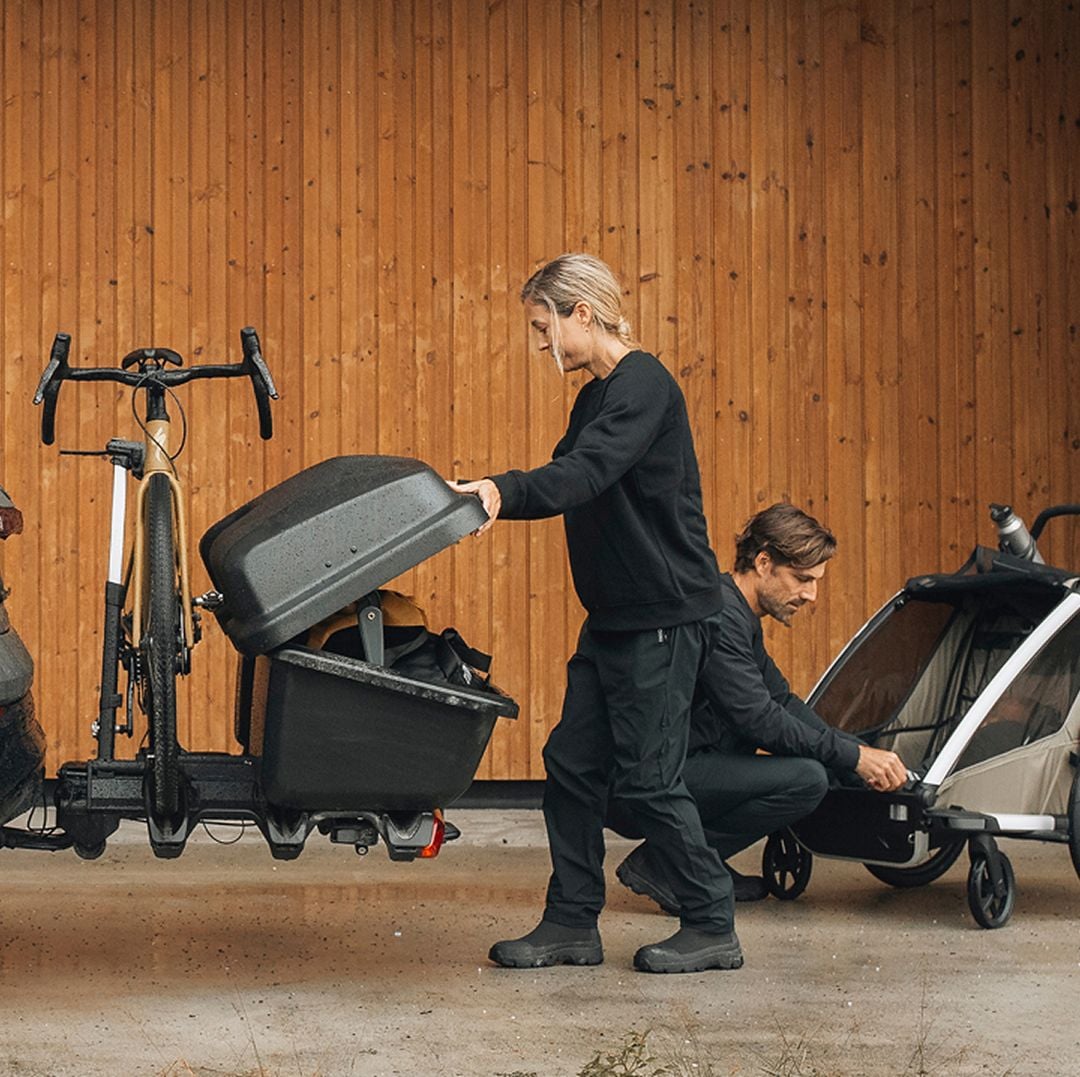 Eine Frau lädt Ausrüstung in einen an einer Abschleppstange montierten Frachtträger.