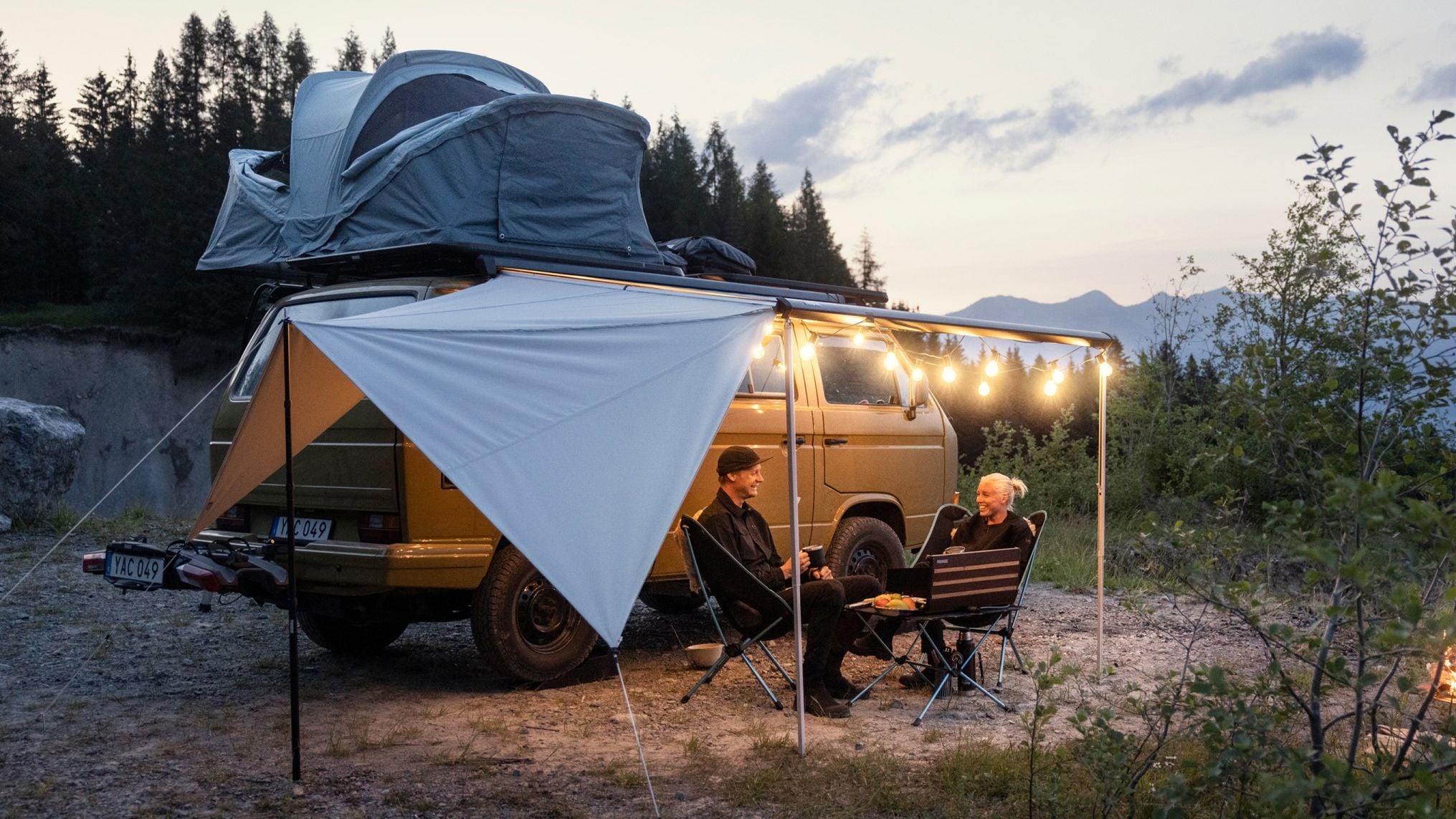 Familiecampingplads med en campervan og Thule Subsola markisepaneler sat op på græs..