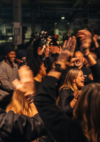 A crowd cheering and celebrating at an indoor event.