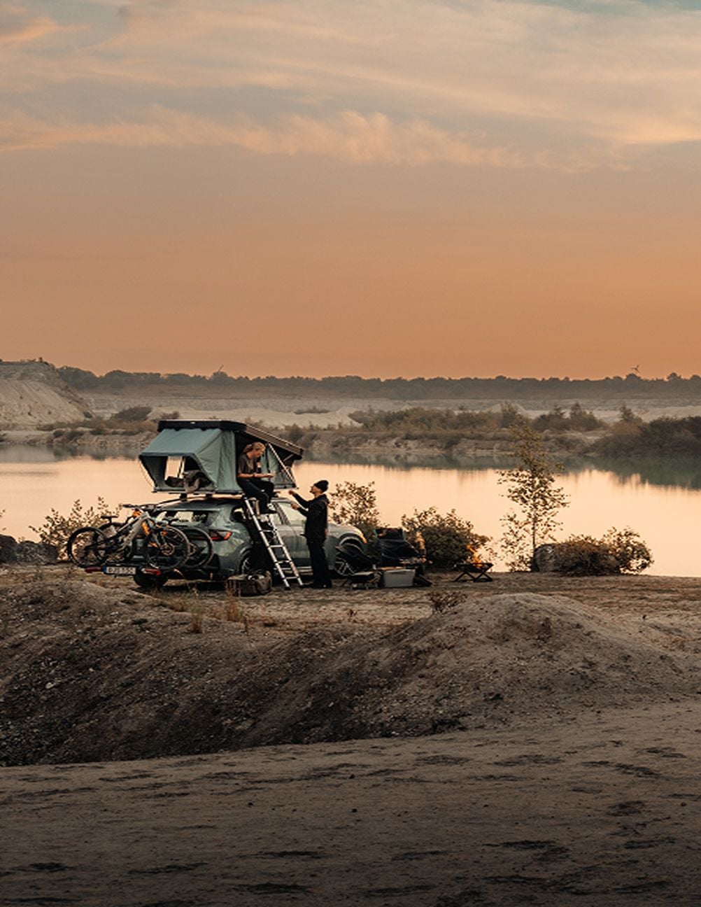 Thule rooftop tent set up by the water at sunset